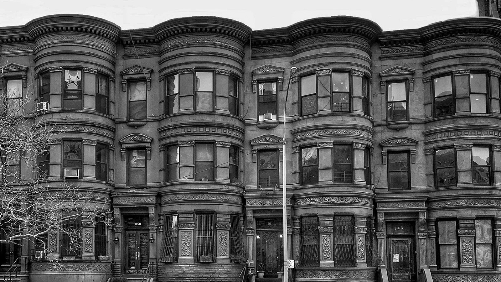A black-and-white photo of the front of an apartment building.