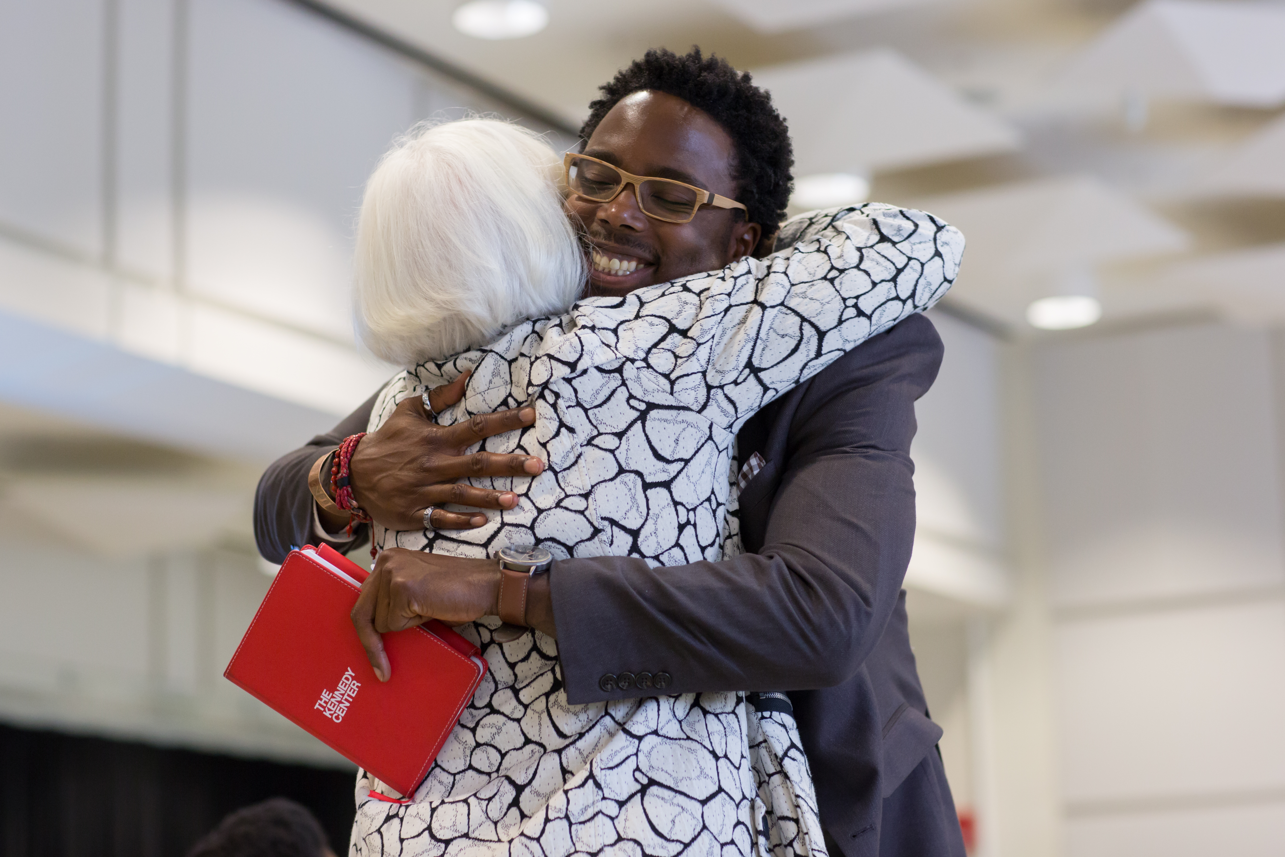 Two staff members give each other a hug